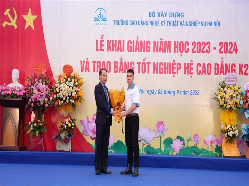 Em Lê Quang Huy, đại diện học sinh, sinh viên nhà trường tặng hoa tri ân Ban lãnh đạo và cán bộ giáo viên Nhà trường